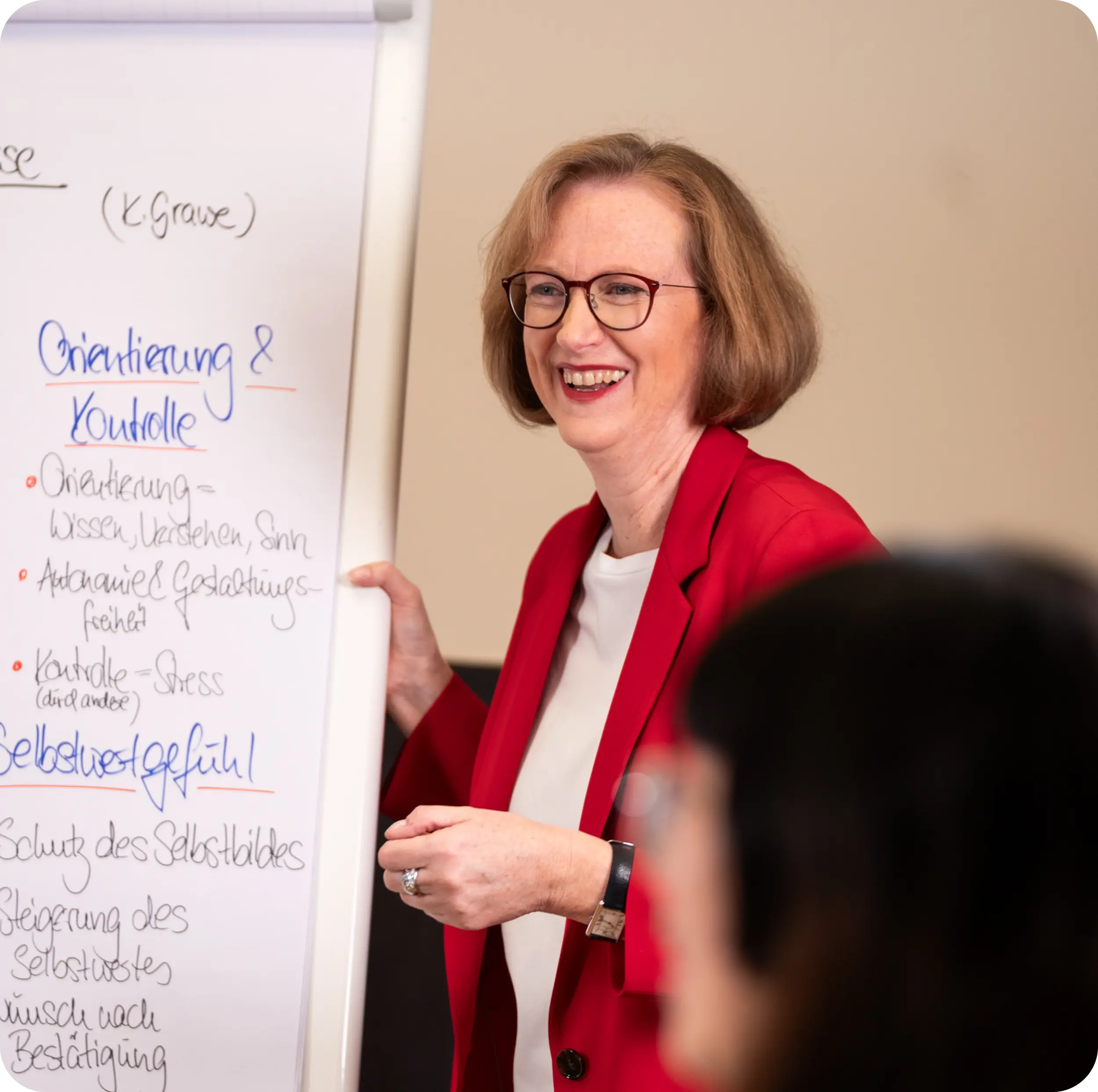 Beraterin erklärt Coaching-Inhalte am Flipchart in einem Workshop bei OMC Berlin