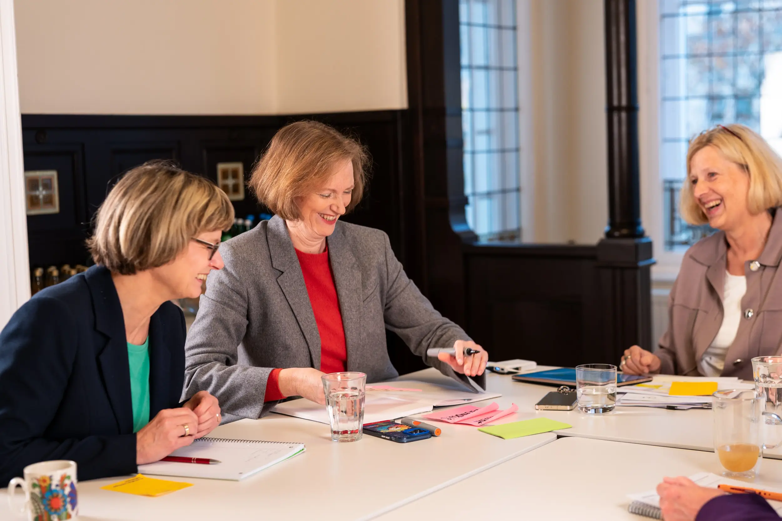 Drei Beraterinnen im lebhaften Austausch beim Personalentwicklungs-Workshop in Berlin